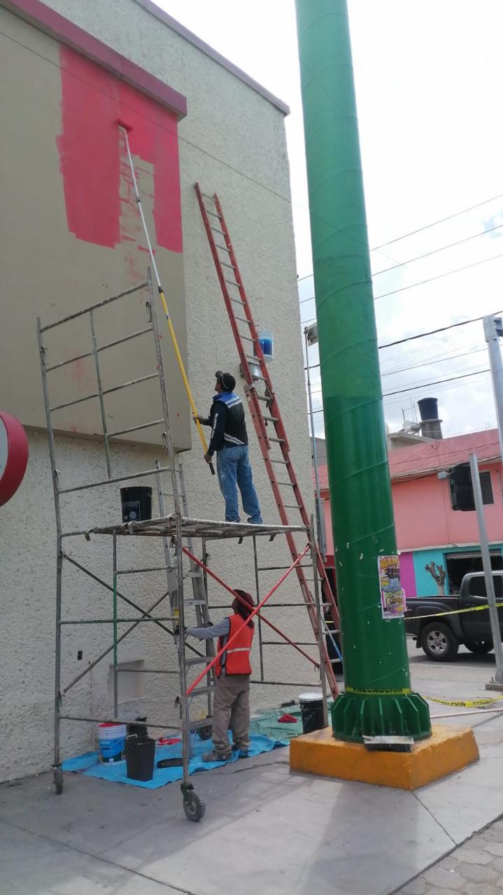 Equipo pintando fachada